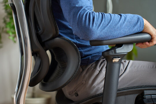 Person adjusting armrest on ergonomic office chair