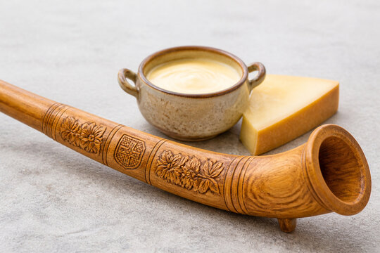Miniature wooden alphorn with fondue pot, Swiss culinary heritage concept
