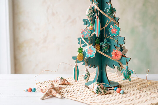 Tropical christmas tabletop tree with sea turtle and pineapple ornaments and starfish for holiday decoration background and seasonal display