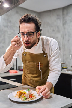 Chef tasting healthy homemade salmon and quinoa meal