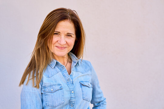 Mature woman smiling wearing casual denim shirt portrait