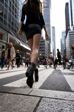 woman walking through a busy city street, urban lifestyle with female pedestrian in motion, contemporary city life and everyday urban movement