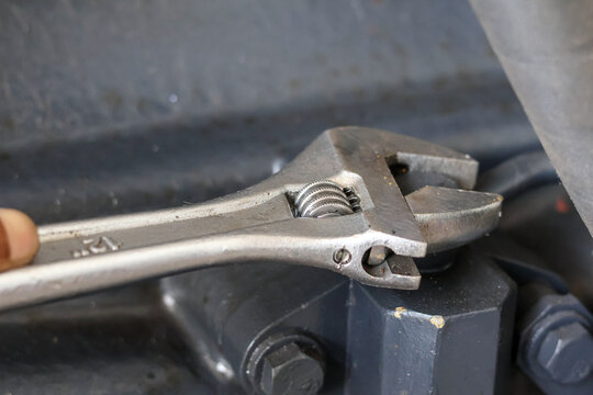 Adjustable wrench on industrial equipment part.