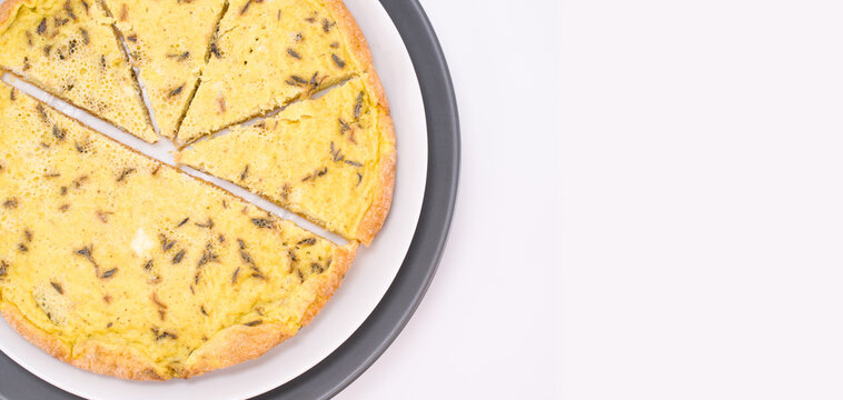 Piatto con fette di frittata alle erbe aromatiche, vista da sopra su una superficie bianca con spazio per testo