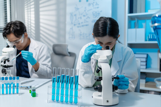 Scientists perform laboratory experiments using microscopes, pipettes and test tubes while analyzing samples in modern research laboratory, representing biotechnology, diagnostics and medical science.