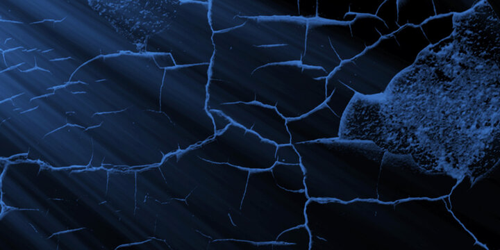 Blue light rays illuminate a cracked blue surface texture creating a dramatic effect