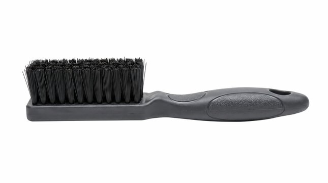 Professional black grooming brush featuring stiff bristles and ergonomic textured handle isolated against a clean solid white studio background area
