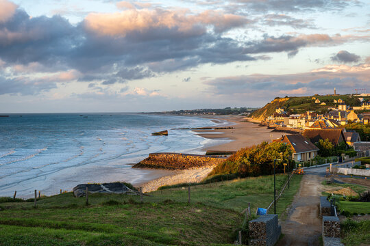Panoramic view of Gold Beach in Arromanches les Bains Normandy France with World War II mulberry harbor remains at sunset