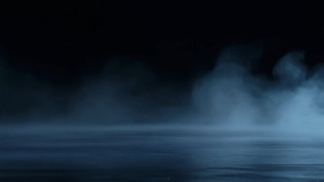 Deep indigo fog rolls slowly across dark reflective surface, gentle billows continuously shifting under cool backlighting with moody serene atmosphere, soft glow, and cinematic depth.