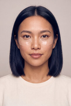 Close portrait of a woman wearing gel under eye patches for a skincare routine and beauty banner or poster background