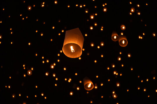 Sky lantern floating in the dark night sky, Tourist floating sky lanterns, Sky lanterns floating on night of Yi Peng, Loy Krathong Festival or Yi Peng Festival in Chiang Mai Thailand.