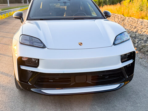 Front view of a white luxury suv parked on a road outdoors in warm evening light porsche macan 4 electric Poland, Pszczyna, 3.08.2026
