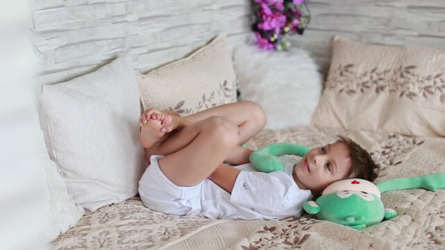 Cute preschool child, boy, playing with toys in a sunny living room