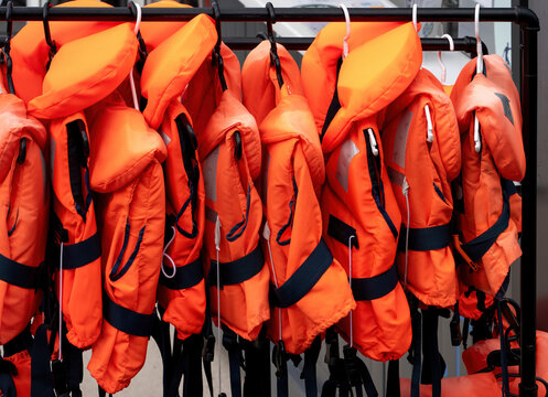 Orange Life Jackets Hanging on Rack at Marina