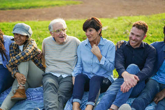 Happy multiracial people with different age having fun together at city park - Multi generational group, community and connection concept