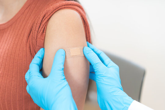 Vaccination coronavirus, hand of doctor apply plaster, bandage after doctor giving vaccine, injection dose on arm patient, immunization disease prevention against flu pandemic influenza, health care.