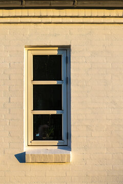 Hirtshals, Denmark A thick yellow brick wall and a window on a house.