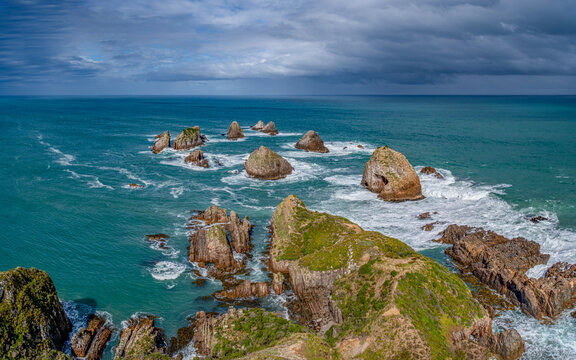 Blick vom Nugget Point Lighthouse auf die Felsstapel The Nuggets im t&uuml;rkisfarbenen Meer, Otago, Neuseeland