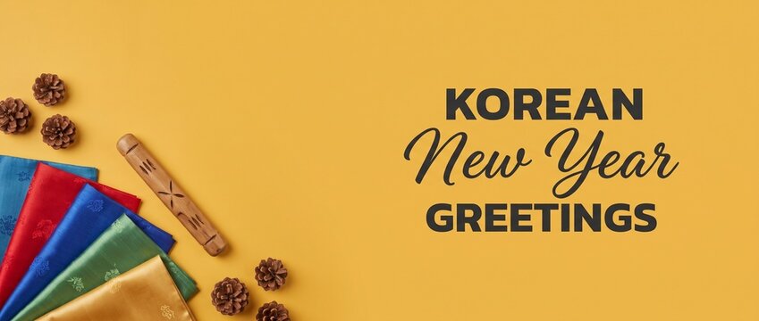Korean New Year Greetings Background with Traditional Silk and Yutnori Stick, Flat Lay Composition on Yellow Banner with Copy Space for Holiday Celebration Event Banner.