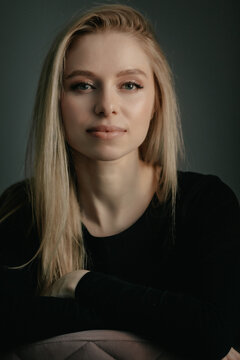 Portrait of a beautiful young blonde woman looking at camera in studio with neutral background