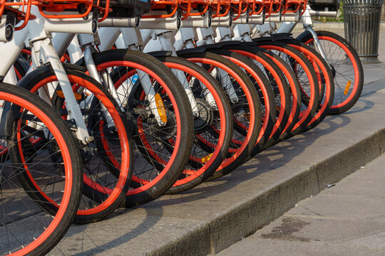 Row of Public Rental Bicycles Parked on an Urban Sidewalk, Showcasing City Mobility and Eco-Friendly Transport Concepts