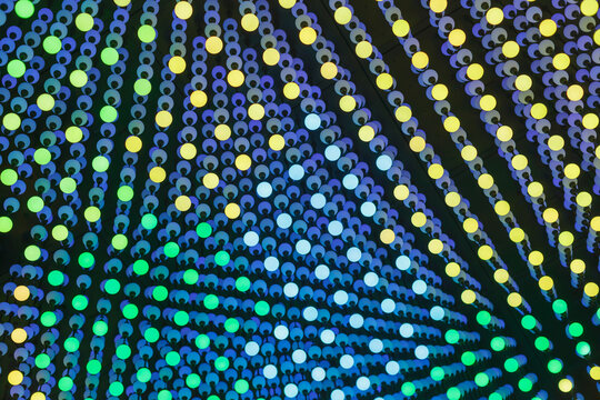  Decorative Light Installation with Blue, Green, and Yellow Glowing Bulbs in Geometric Patterns. Abstract Colorful Background for Events.