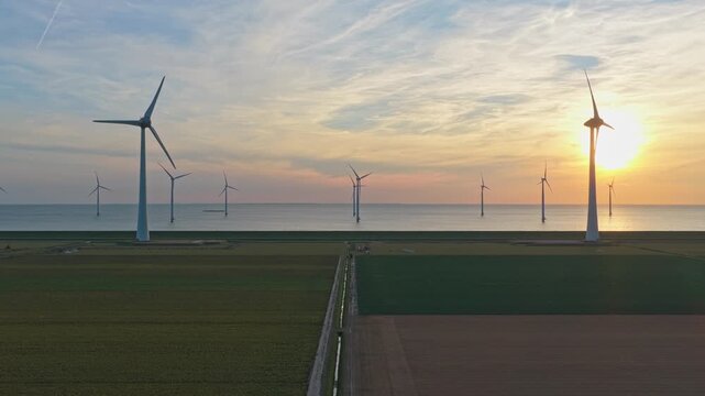 Aerial view of offshore wind turbines generating renewable energy at sunset