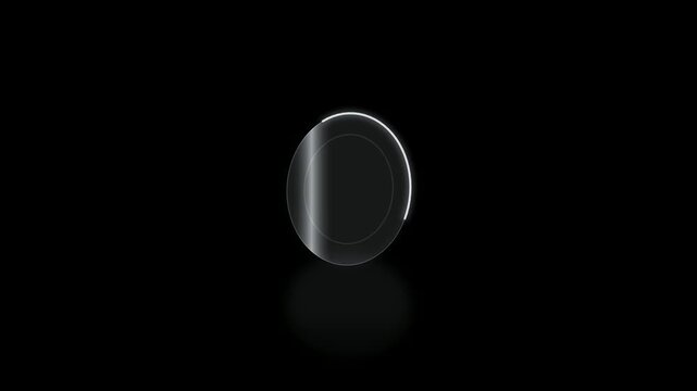 A minimalist shot of a reflective circular object with a gradient of light and shadow on a black background.