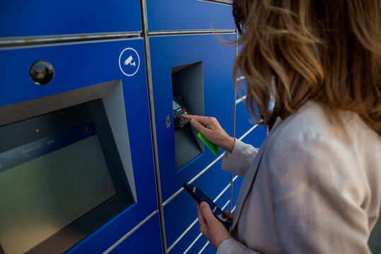 Close-up of a woman paying with a card at the parcel locker