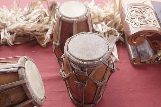 Authentic Indonesian Gamelan drums and cultural instruments displayed on red fabric
