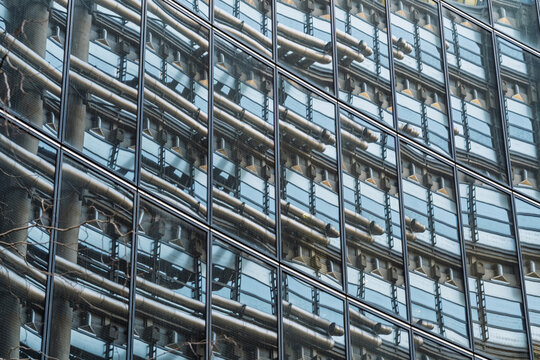 View of the glass and steel facade of the Lloyd's Building, showcasing its distinctive external service pipes and structural framework in London, England, United Kingdom.