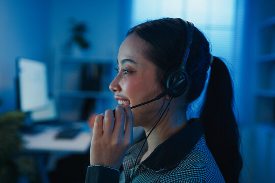 Closeup Gen z Asia young call center team or customer support service executive use computer and microphone headset work technical e commerce in late night office. Telemarketing or sales job concept.