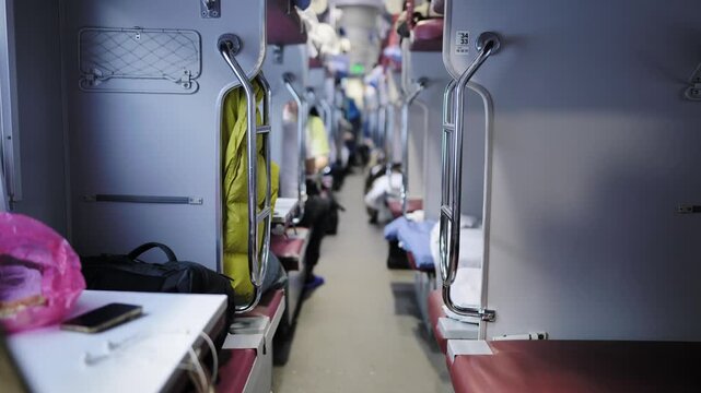 Interior of a long-distance sleeper train carriage with passengers traveling