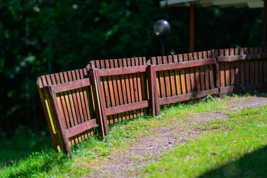 Rustic wooden fence bordering quiet green yard in summer.