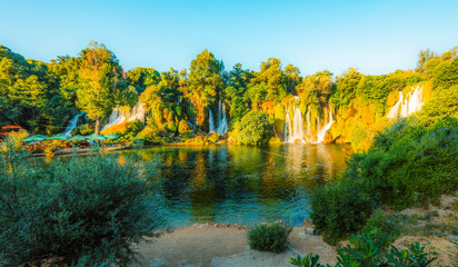 Kravice Waterfalls on the Trebižat River, a natural amphitheater of cascading water and lush green nature near Ljubuški, Bosnia and Herzegovina. © Zedspider