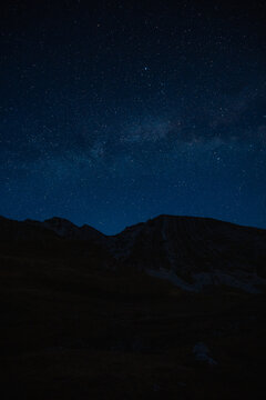 Grand panoramic view from Prutas peak at night with sky, overlooking the dramatic limestone ridges and deep valleys of Durmitor National Park, Montenegro.