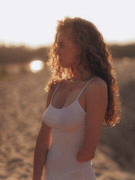 Amputee Woman Standing on Sand Dune in Sunset Backlight