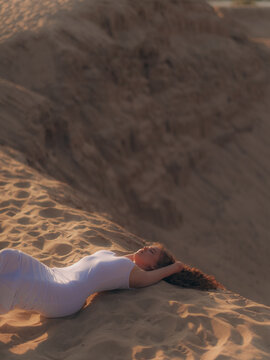 Amputee Woman Lying and relaxing on Sand Dune at Sunset