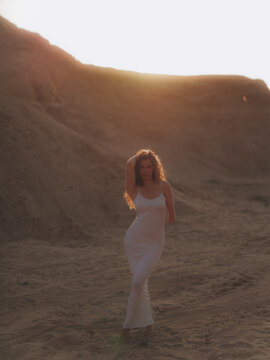 Amputee Woman Standing on Sand Dune at Sunset
