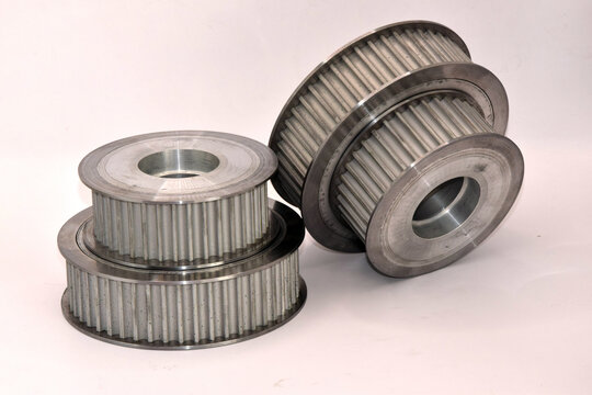 Set of precision machined aluminum and steel synchronous pulleys, spur gears, and drive components used in industrial machinery engineering and mechanical power transmission systems.