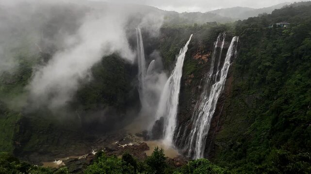 mist and rain, an overflowing jog falls creates a scenic cascade. waterfalls with mist and rain