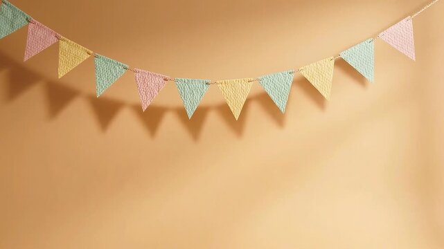 Colorful paper bunting garland hanging against a solid beige wall. Decorative triangular flags for party celebration. Festive concept for birthday or event decor.