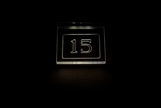 Glowing number 15 sign on a dark background, modern minimal design, perfect for signage, addresses, or digital concepts.