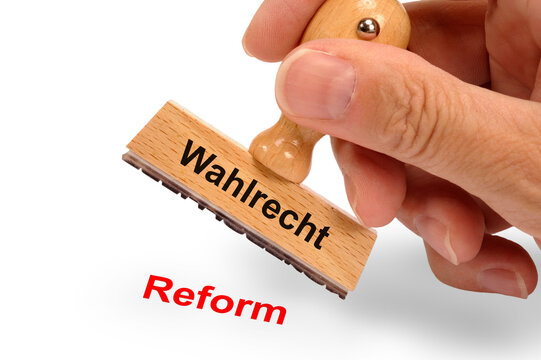 Ein Holzstempel ist beschriftet mit dem Aufdruck: Wahlrecht und dem Abdruck: Reform