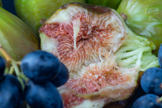 Sliced fig with dark grapes close up, fresh fruit pairing food photography