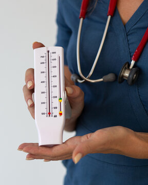 A doctor holds a peak flow meter in his hands. A device for measuring maximum expiratory flow rate. It is used to diagnose bronchial asthma.