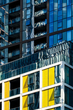 Within London, Isle of Dogs, England, a residential tower of glass apartments combines windows, color and facade contrast in a tight architectural crop.