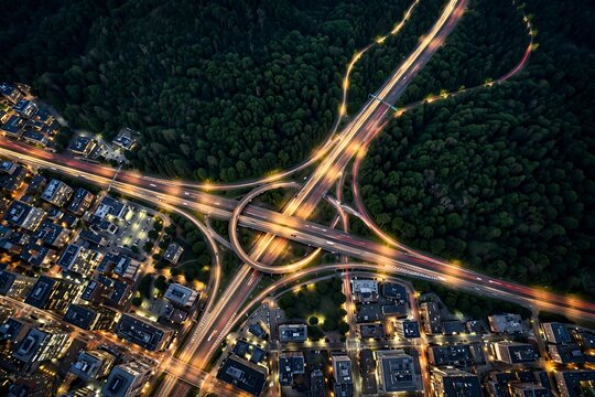 Aerial view of highway interchange loop road at night with illuminated streetlights and city lights