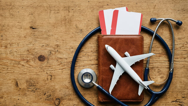 Travel insurance concept stethoscope passport ticket airplane holiday health safety medical care tourism vacation planning background wood table flatlay