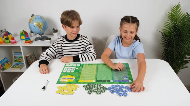 High-quality 4k video footage of happy children learning place value and counting with magnetic game set. Elementary students sitting at table for interactive education concept.